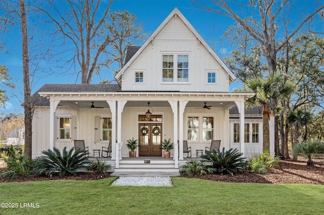 view of front facade featuring covered porch, a front lawn, ceiling fan, and french doors