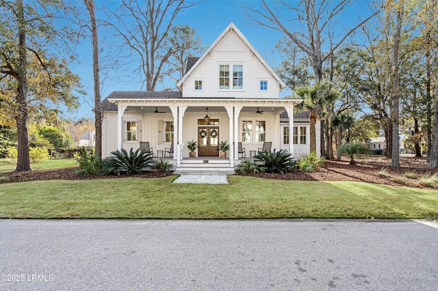 modern inspired farmhouse with a front yard, french doors, ceiling fan, and a porch