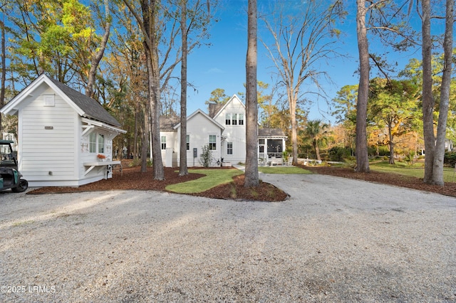 view of front facade with a sunroom and a front yard