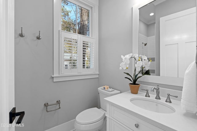 bathroom with vanity, a wealth of natural light, toilet, and walk in shower