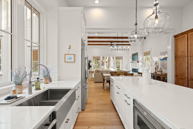 kitchen with beamed ceiling, light stone countertops, light hardwood / wood-style flooring, and white cabinets