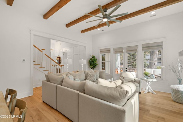 living room with beamed ceiling, ceiling fan, light wood-type flooring, and french doors