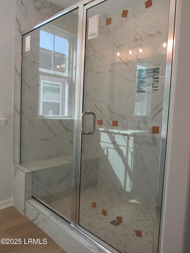 full bath with a healthy amount of sunlight and a marble finish shower