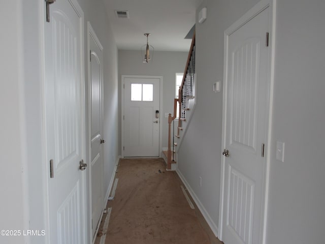 entryway with stairway, baseboards, and visible vents