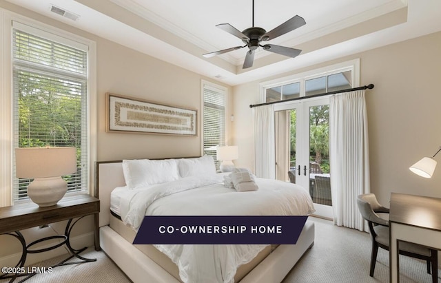 carpeted bedroom with access to exterior, visible vents, a tray ceiling, ornamental molding, and french doors