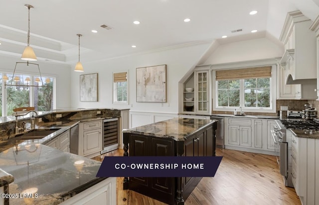 kitchen with wine cooler, a healthy amount of sunlight, appliances with stainless steel finishes, and a sink