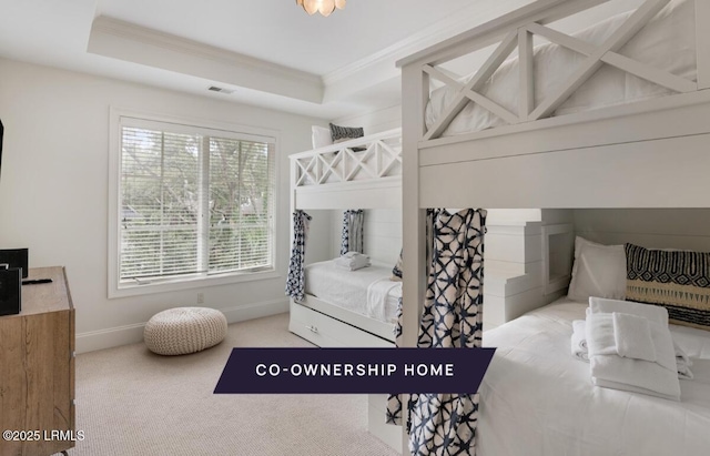 carpeted bedroom featuring visible vents, a raised ceiling, baseboards, and crown molding