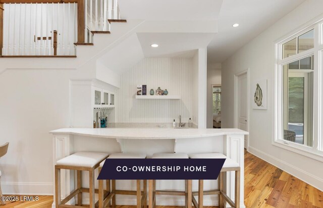 bar with light wood-style flooring, recessed lighting, and baseboards