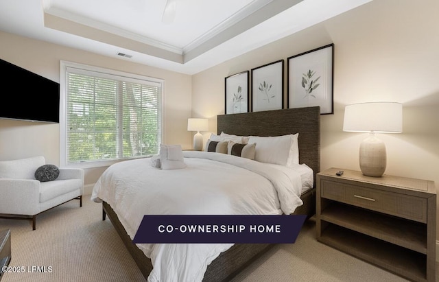 carpeted bedroom with a tray ceiling, visible vents, and crown molding