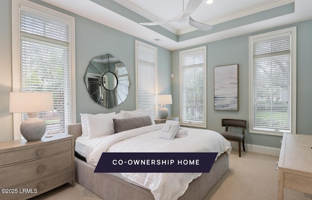 bedroom with a tray ceiling, multiple windows, and ornamental molding