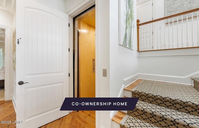 stairway with baseboards and wood finished floors