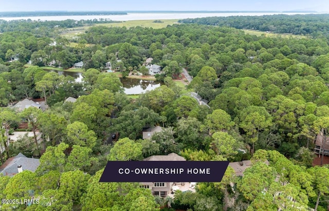 bird's eye view featuring a wooded view and a water view