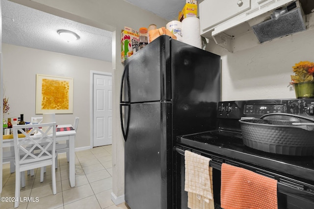 kitchen with black appliances, a textured ceiling, and light tile patterned flooring