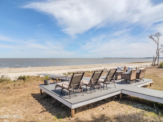 exterior space featuring a deck with water view and a view of the beach