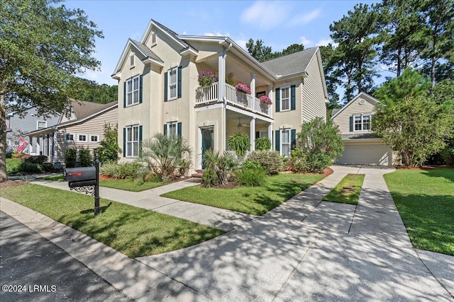 21 Woods Bay Rd, Bluffton, SC 29910 - view of front of home featuring a balcony, a front yard, stucco siding, and a garage