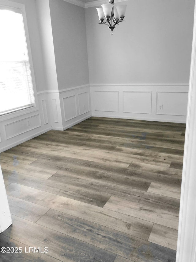 unfurnished dining area with dark wood-type flooring and a notable chandelier