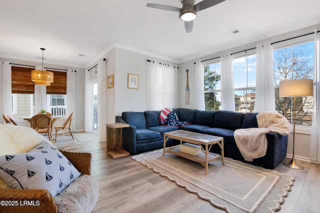 living room with crown molding, light hardwood / wood-style flooring, and ceiling fan