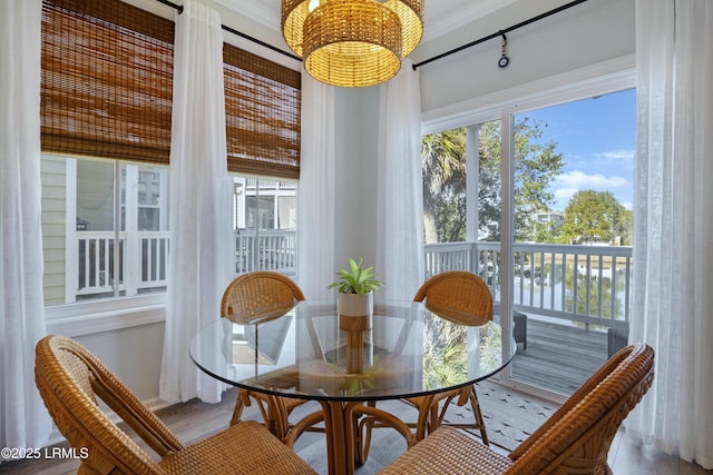 sunroom / solarium featuring a notable chandelier and a water view