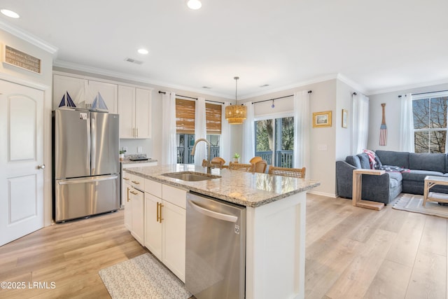 kitchen featuring appliances with stainless steel finishes, sink, a center island with sink, and white cabinets