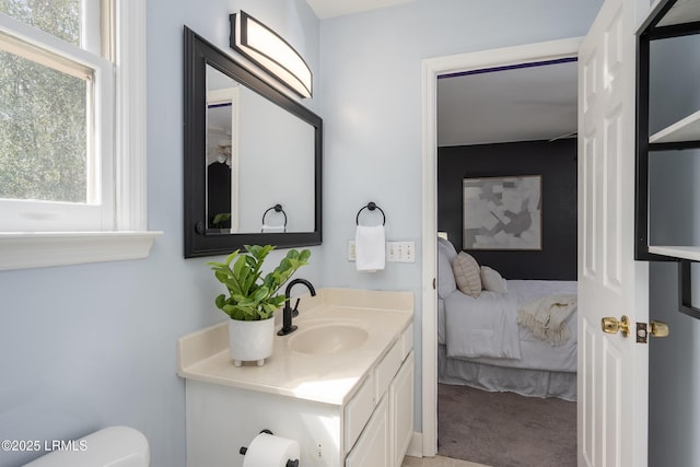 bathroom featuring toilet, connected bathroom, and vanity