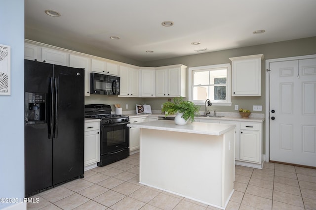 kitchen featuring black appliances, light tile patterned flooring, a sink, and white cabinetry