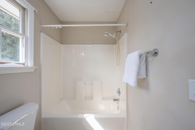 bathroom featuring shower / bathtub combination and toilet