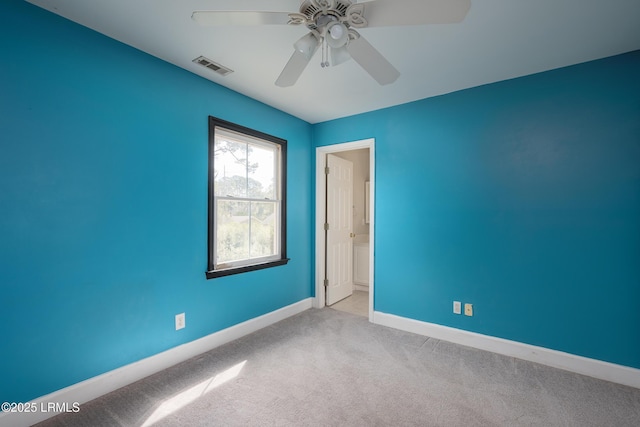 spare room featuring carpet floors, visible vents, ceiling fan, and baseboards