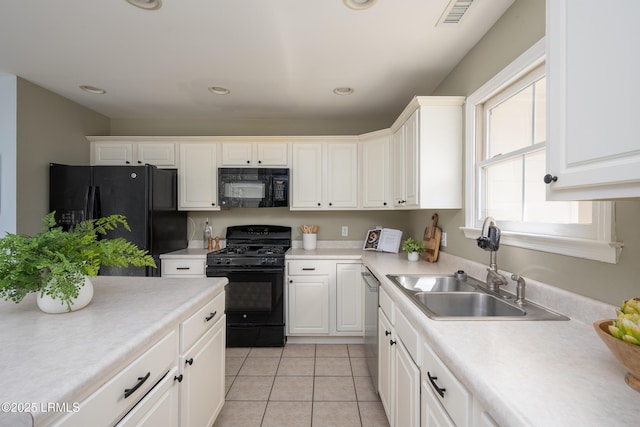 kitchen featuring white cabinets, visible vents, a sink, and black appliances