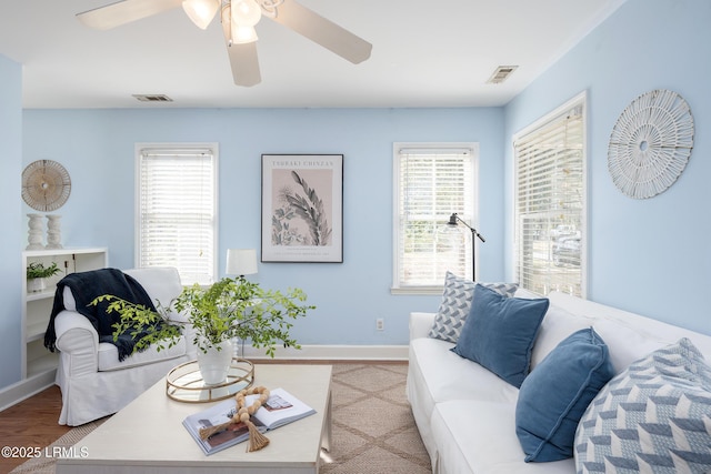 living room with light wood-type flooring, plenty of natural light, and visible vents