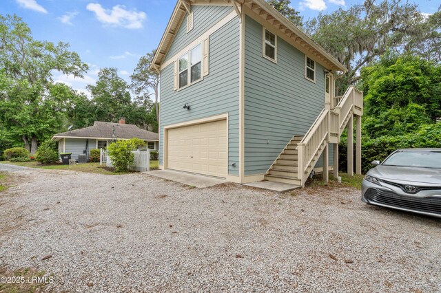 117 Elliott St, Beaufort, SC 29902 - view of side of property with stairway, a garage, and gravel driveway