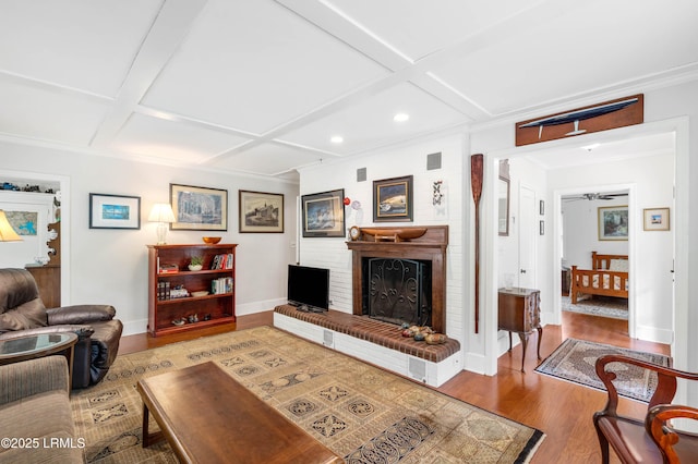 117 Elliott St, Beaufort, SC 29902 - living area with coffered ceiling, wood finished floors, baseboards, a fireplace, and crown molding