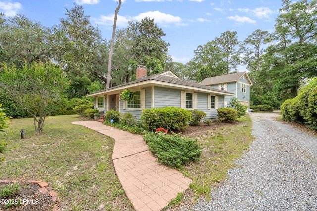 117 Elliott St, Beaufort, SC 29902 - view of side of property featuring a chimney, gravel driveway, and view of wooded area