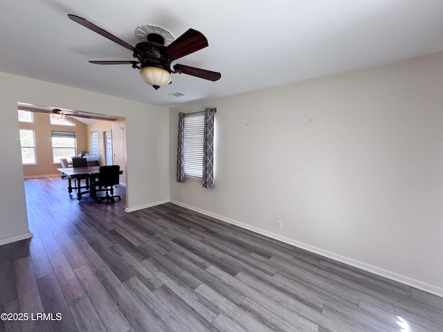 interior space featuring dark wood-style floors, visible vents, baseboards, and a ceiling fan