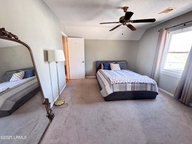 bedroom with carpet, visible vents, vaulted ceiling, a textured ceiling, and baseboards