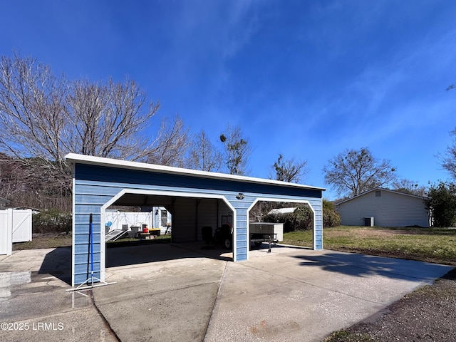 view of car parking featuring driveway and fence