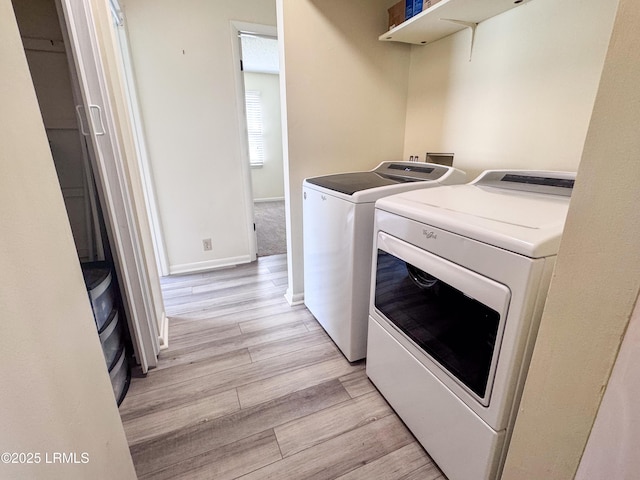 laundry room featuring light wood-type flooring, laundry area, baseboards, and independent washer and dryer