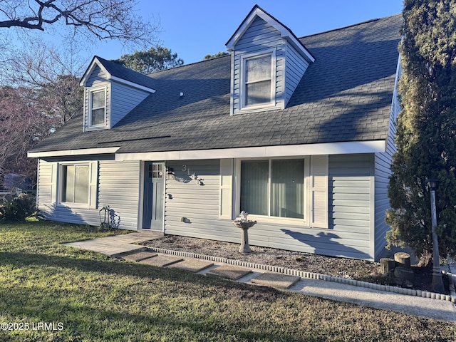 rear view of house featuring a yard and roof with shingles