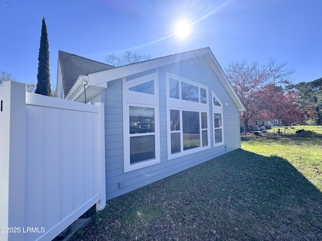 view of home's exterior featuring roof with shingles and a lawn