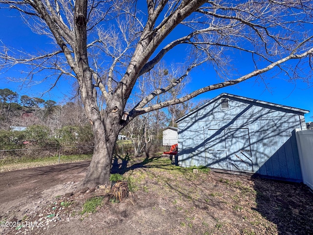 view of yard with an outbuilding, a storage shed, and fence