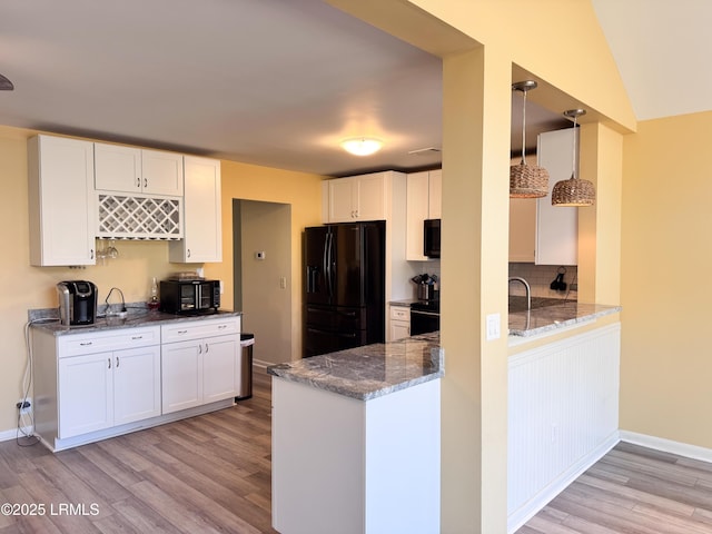 kitchen featuring black appliances, stone countertops, white cabinetry, and light wood-style floors