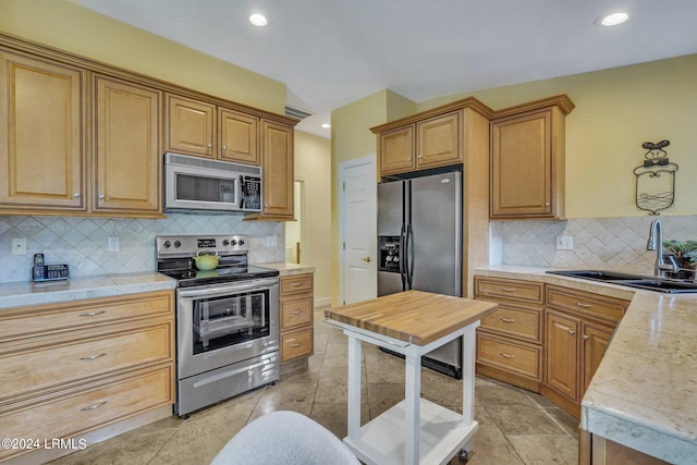 kitchen featuring tasteful backsplash, appliances with stainless steel finishes, and sink