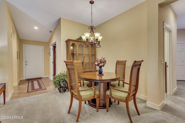 dining room featuring lofted ceiling, a notable chandelier, and light colored carpet