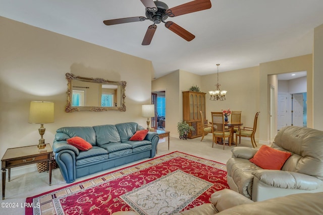 carpeted living room with ceiling fan with notable chandelier