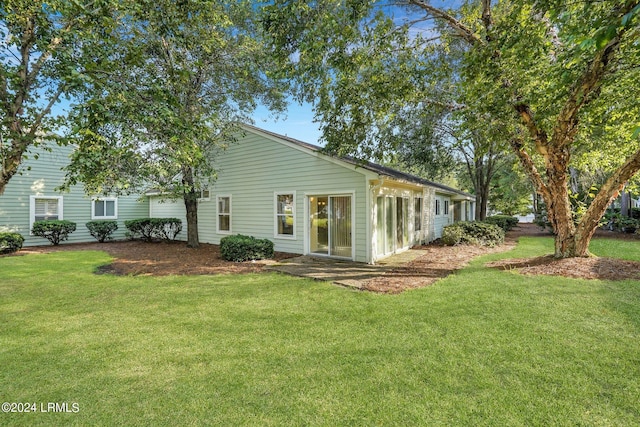 rear view of property with a lawn