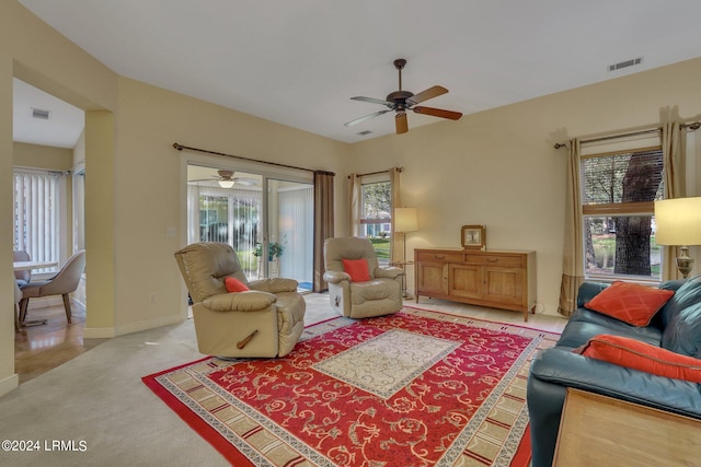 carpeted living room with ceiling fan