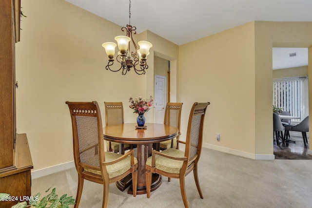 carpeted dining space featuring a notable chandelier