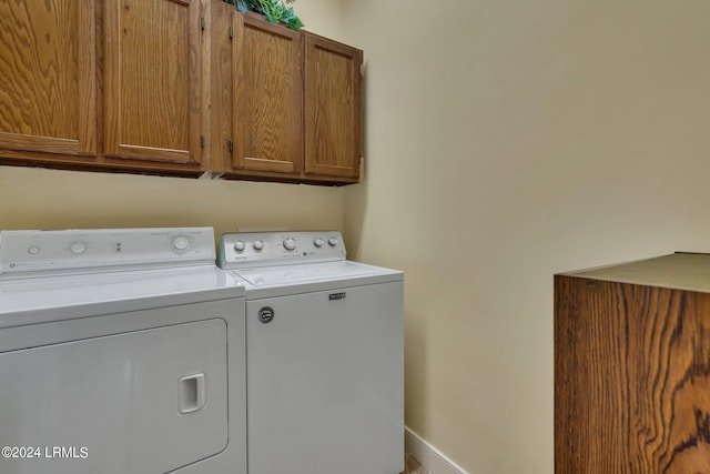 washroom with cabinets and washer and clothes dryer