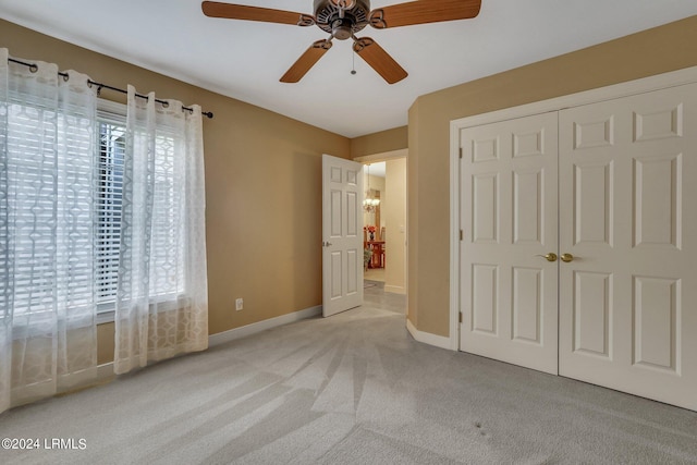 unfurnished bedroom featuring ceiling fan, light carpet, and a closet