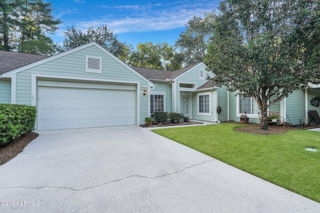 ranch-style house featuring a garage and a front lawn