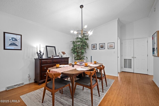 3 Stono Ct, Beaufort, SC 29902 - dining area with crown molding, light wood-style floors, a chandelier, baseboards, and a textured ceiling
